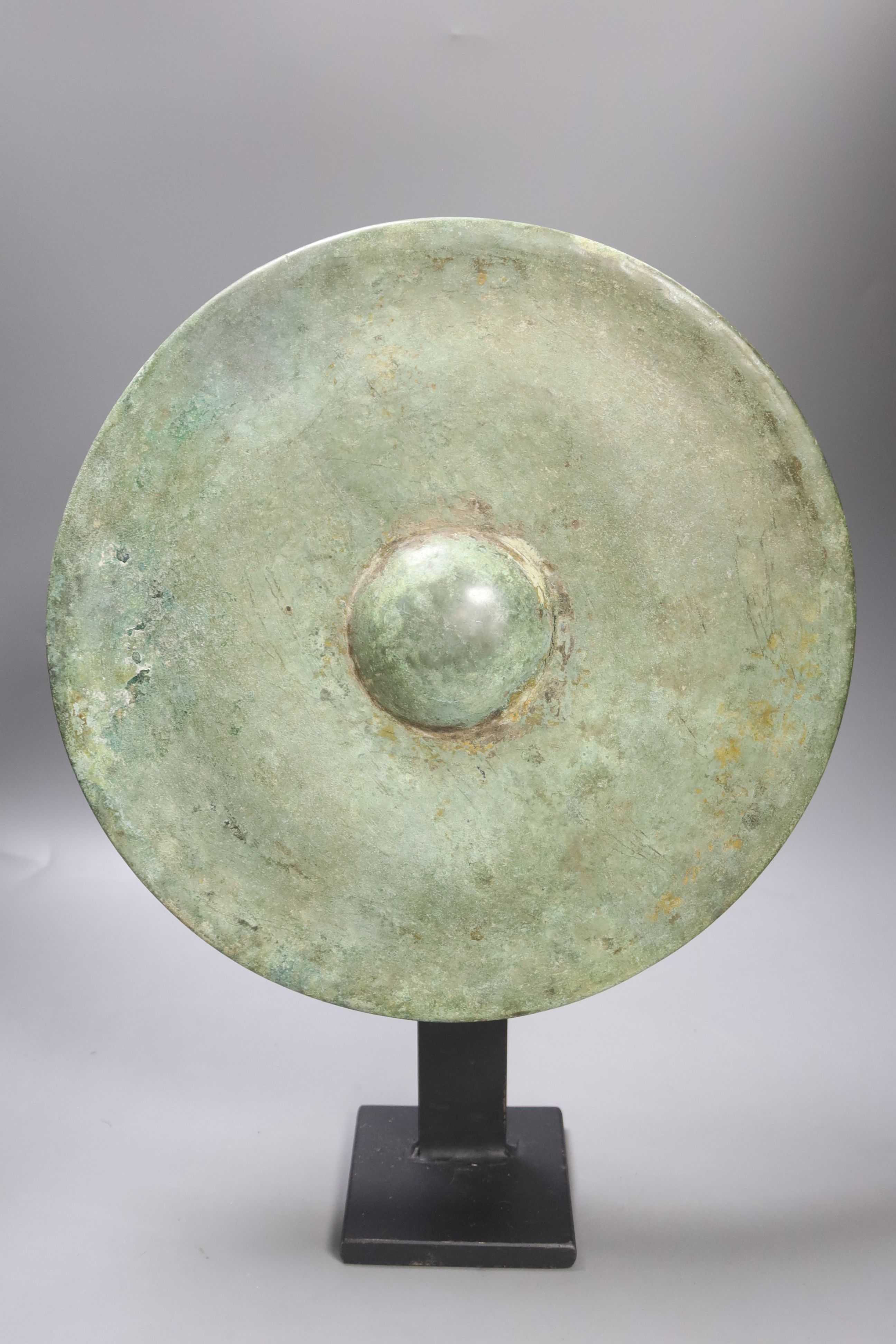 A Cambodian bronze gong, Khmer 12th/13th century, later metal stand 33cm diam